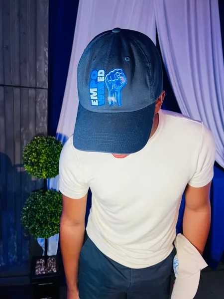 Person wearing the navy Empowered event cap designed by Surge