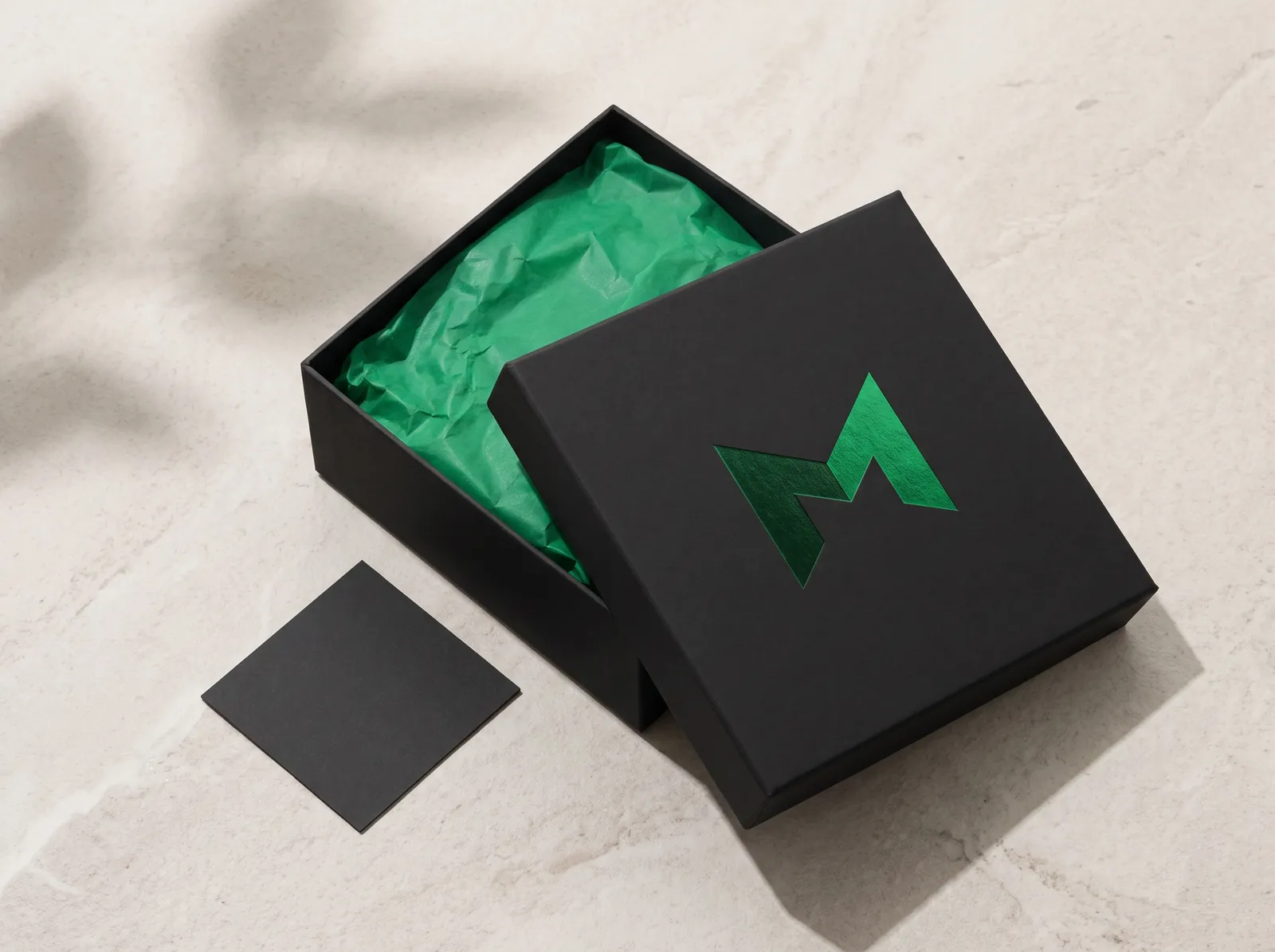 Black gift box with a green foil Surge M and green tissue
